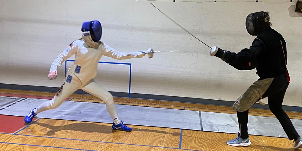 Coach Benoit Bouysset fencing with a young athlete.