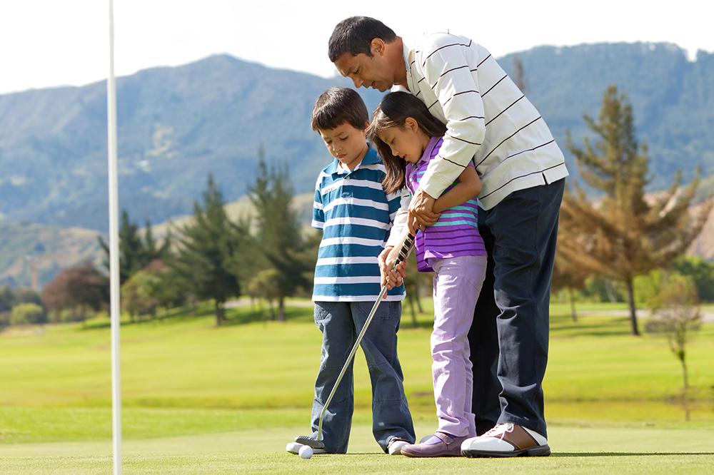 dad teaching kid to golf