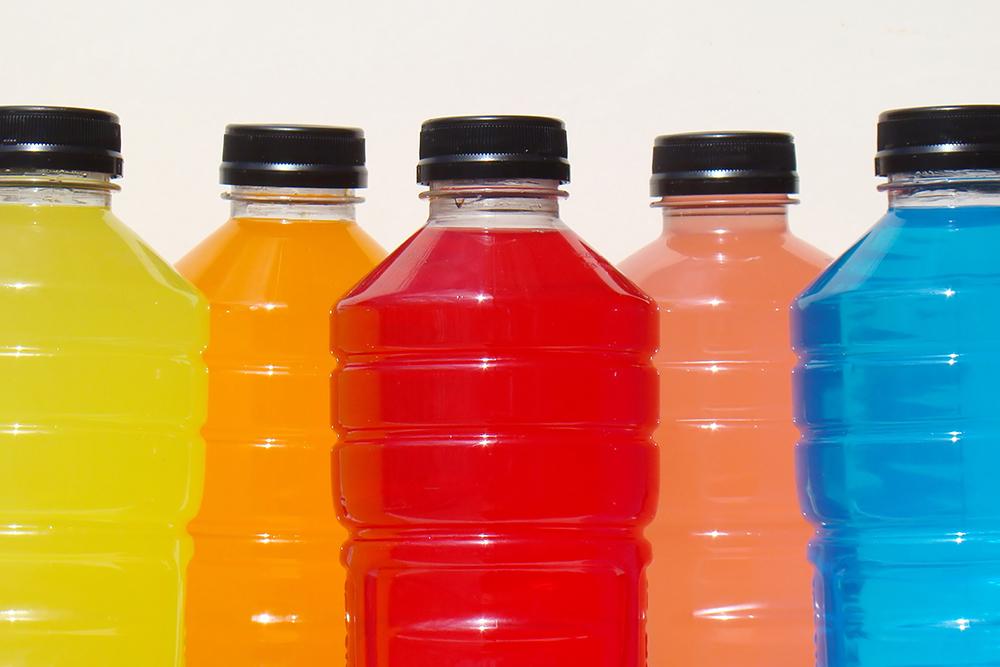 Different colored sports drink on a white background.