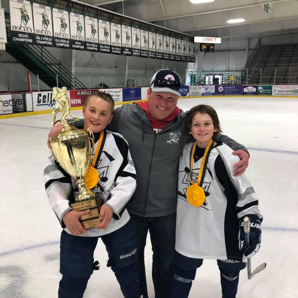 Ice hockey coach Greh Krahn with two young athletes.