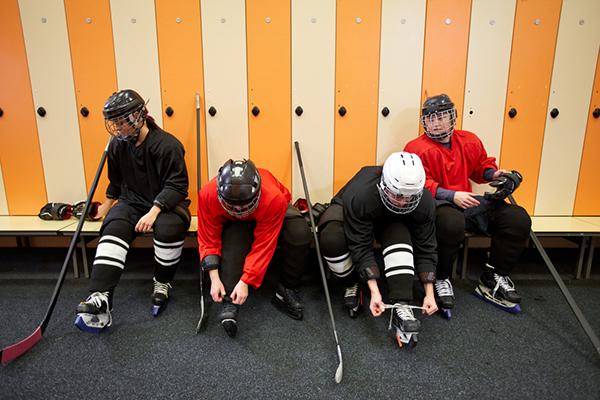 Small group of young hockey players in locker room.